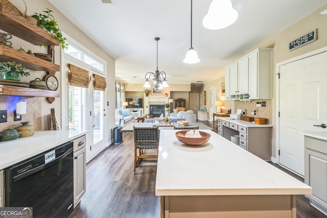 kitchen with tasteful backsplash, dishwasher, a kitchen island, light stone countertops, and dark hardwood / wood-style floors