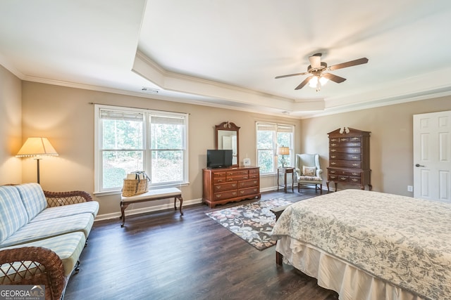 bedroom featuring dark wood-type flooring, ceiling fan, ornamental molding, and a tray ceiling