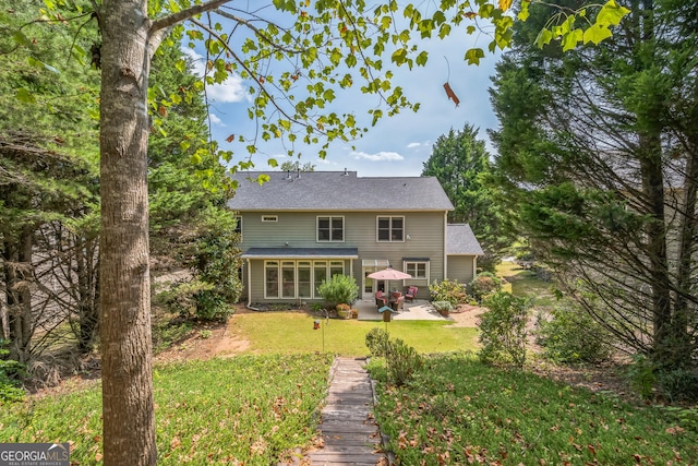 rear view of house with a yard, a patio, and a sunroom