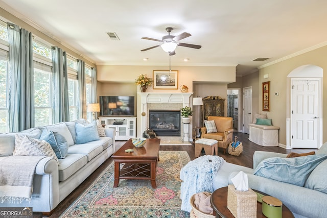 living room featuring dark wood-type flooring, ceiling fan, and crown molding