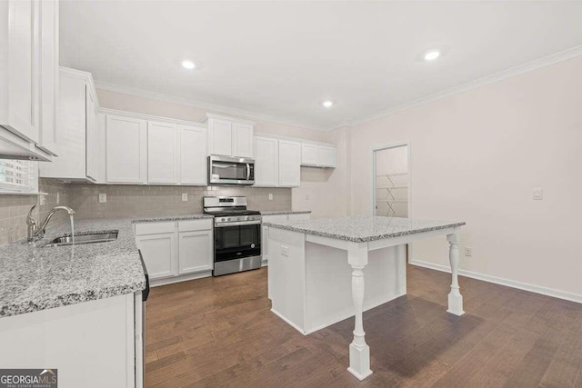 kitchen featuring light stone countertops, appliances with stainless steel finishes, a center island, and white cabinets