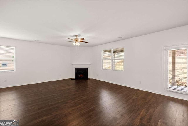 unfurnished living room with dark hardwood / wood-style floors and ceiling fan