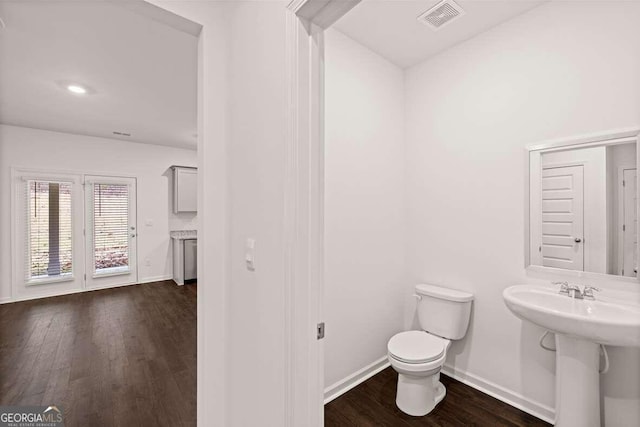 bathroom with hardwood / wood-style flooring, toilet, and sink