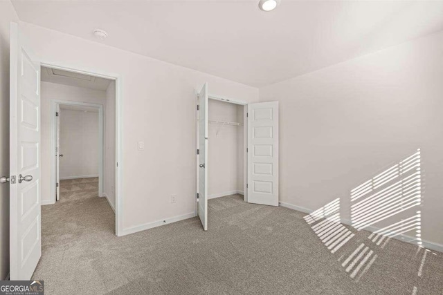 unfurnished bedroom with light colored carpet and a closet