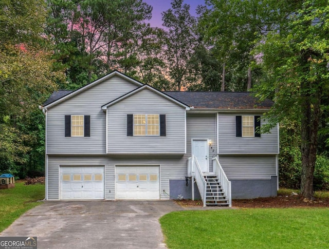 raised ranch with a yard and a garage