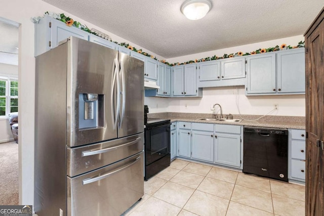 kitchen with black appliances, light tile patterned floors, a textured ceiling, and sink