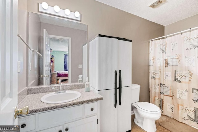 bathroom featuring a textured ceiling, vanity, a shower with shower curtain, tile patterned flooring, and toilet