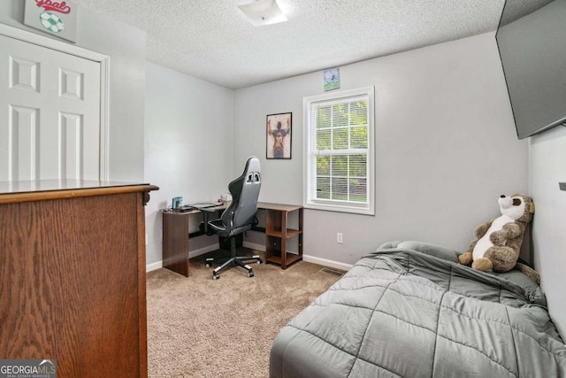 bedroom with a textured ceiling and light carpet