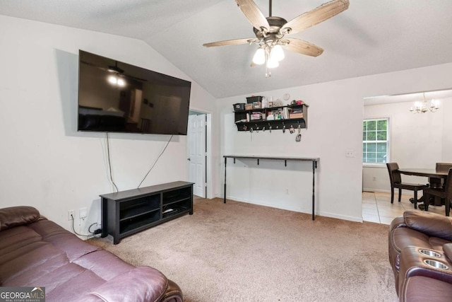 living room with ceiling fan with notable chandelier, vaulted ceiling, and light carpet