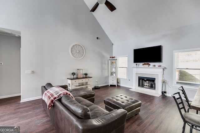 living room with ceiling fan, dark wood-type flooring, a high end fireplace, and high vaulted ceiling