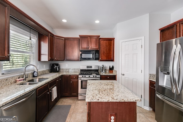 kitchen with light stone counters, light tile patterned flooring, sink, a kitchen island, and appliances with stainless steel finishes