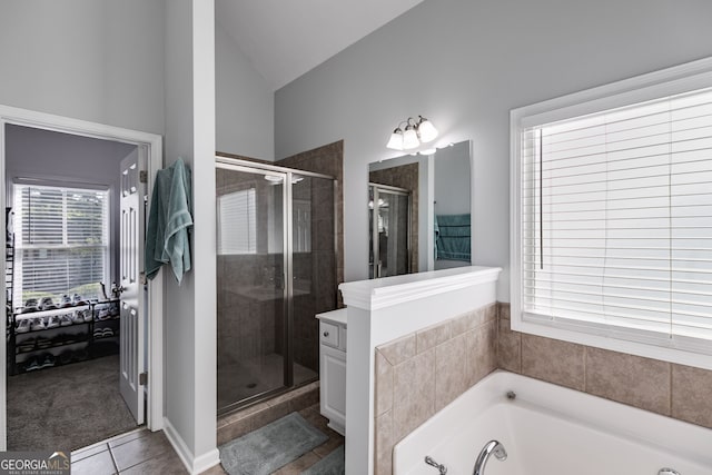 bathroom with independent shower and bath, lofted ceiling, and tile patterned floors