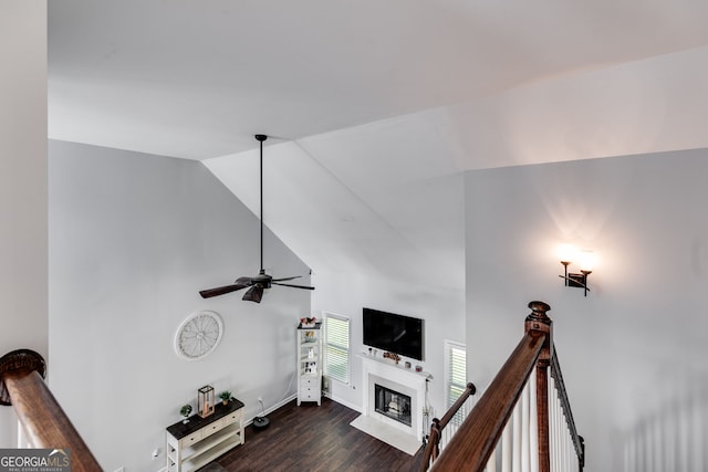 living room featuring dark hardwood / wood-style flooring, ceiling fan, and high vaulted ceiling