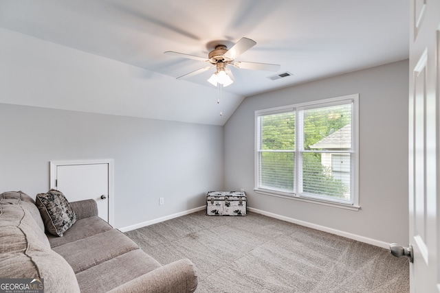 living room with ceiling fan, carpet flooring, and vaulted ceiling