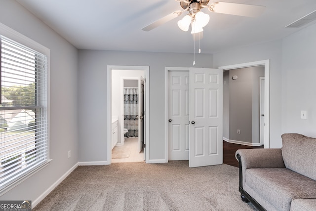 living area with ceiling fan, light colored carpet, and plenty of natural light