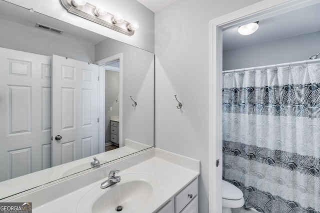 bathroom with a shower with curtain, vanity, and toilet