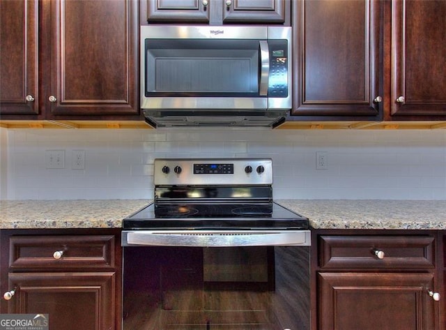 kitchen with appliances with stainless steel finishes, backsplash, dark brown cabinetry, and light stone counters