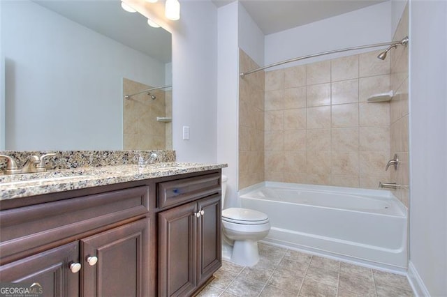 full bathroom featuring tile patterned flooring, tiled shower / bath, vanity, and toilet