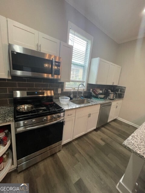 kitchen featuring light stone countertops, sink, stainless steel appliances, and white cabinets