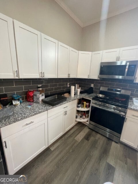 kitchen with light stone counters, appliances with stainless steel finishes, and white cabinets