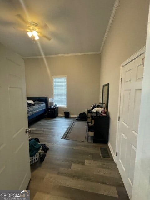 interior space featuring ornamental molding, ceiling fan, and dark hardwood / wood-style floors