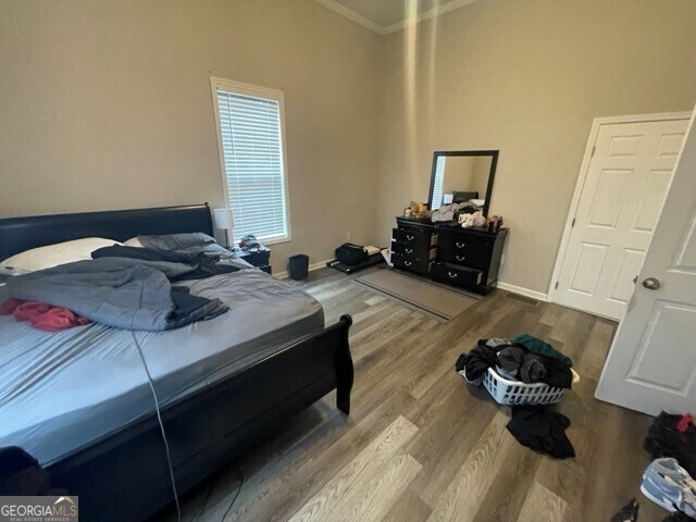 bedroom with crown molding and hardwood / wood-style flooring