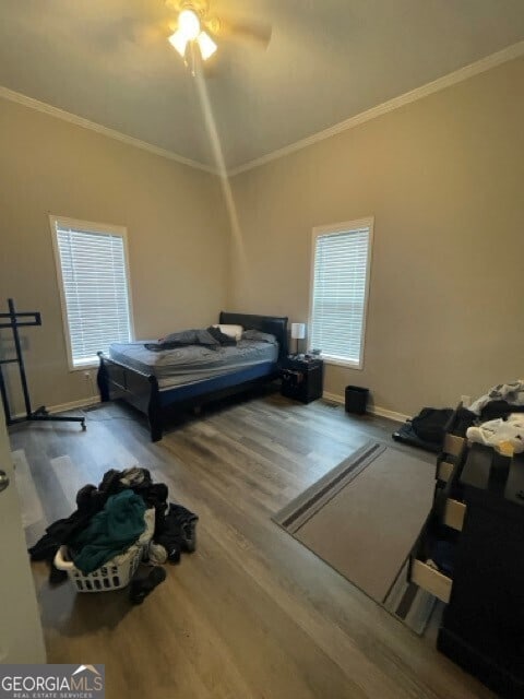 bedroom with crown molding, ceiling fan, and wood-type flooring