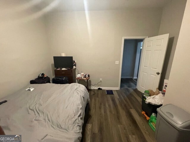 bedroom with dark hardwood / wood-style floors