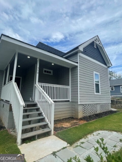 view of side of property featuring covered porch