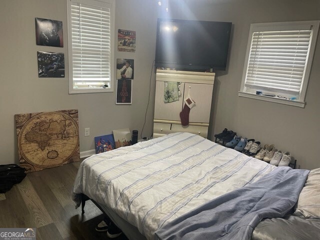 bedroom with multiple windows and hardwood / wood-style flooring