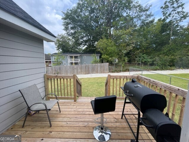 wooden deck featuring a lawn