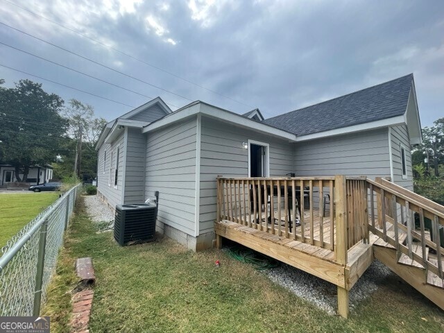 back of house with a wooden deck, a yard, and central AC unit