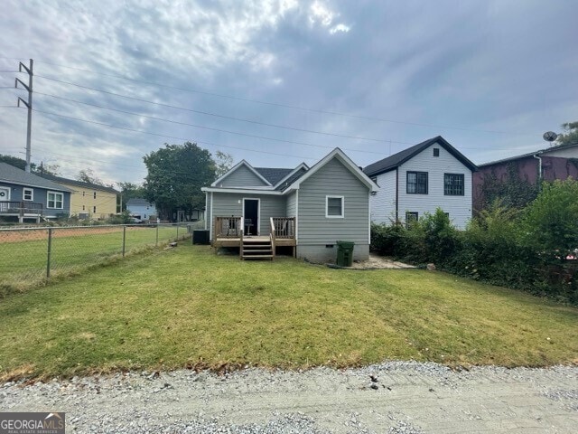 view of front of house featuring a front lawn and a wooden deck