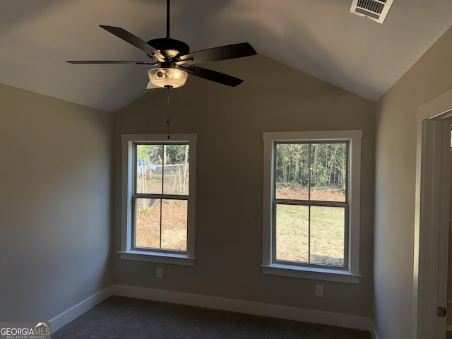 empty room with vaulted ceiling, a healthy amount of sunlight, visible vents, and baseboards