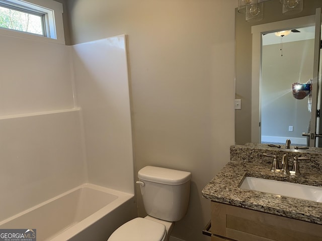 bathroom featuring toilet, shower / washtub combination, and vanity