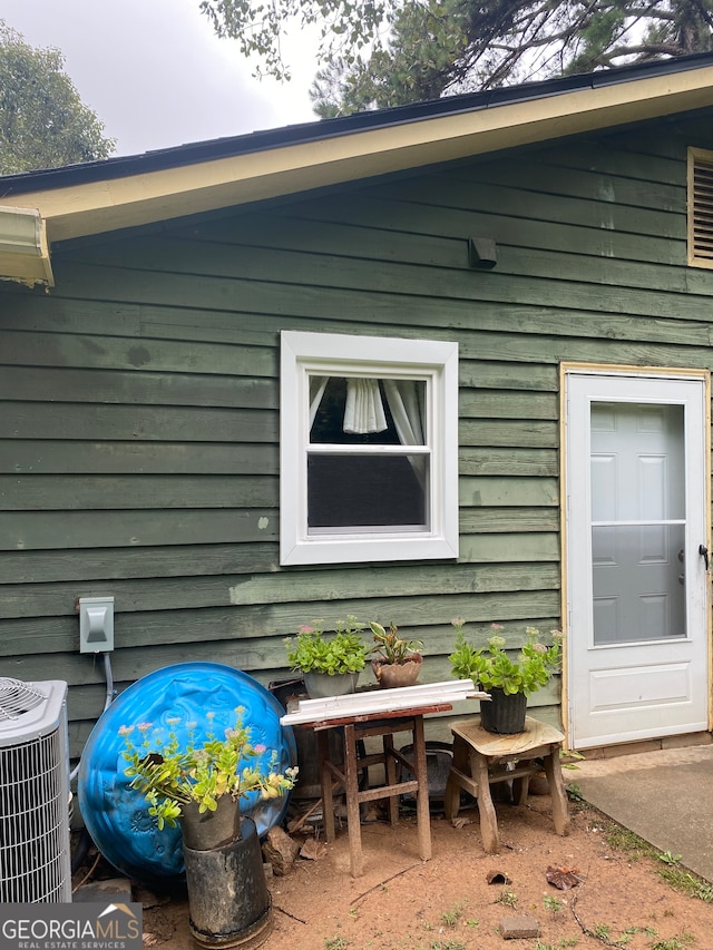 view of side of property with a patio area and central AC