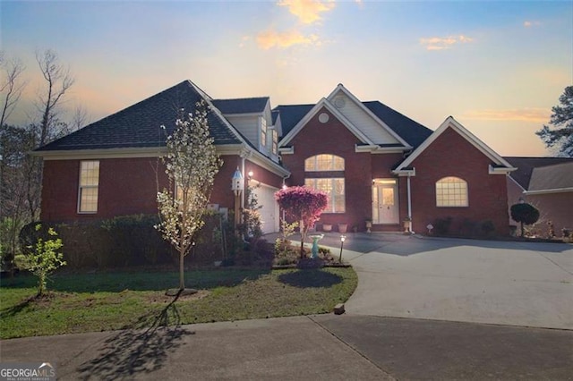 view of front of home with a garage, concrete driveway, and a front lawn