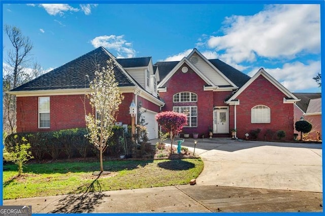 traditional-style home featuring a garage, a front lawn, brick siding, and driveway