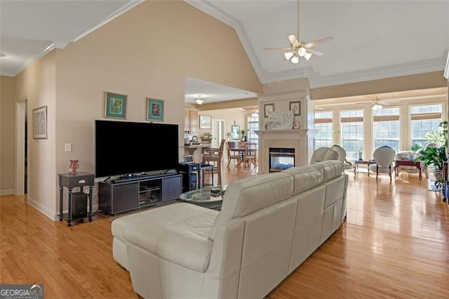 living room with light wood-type flooring, high vaulted ceiling, ceiling fan, and crown molding