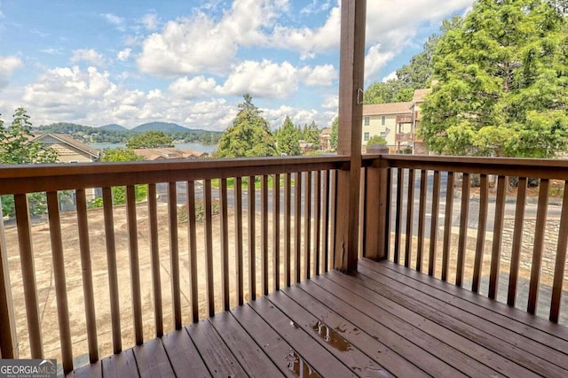 wooden deck with a water and mountain view