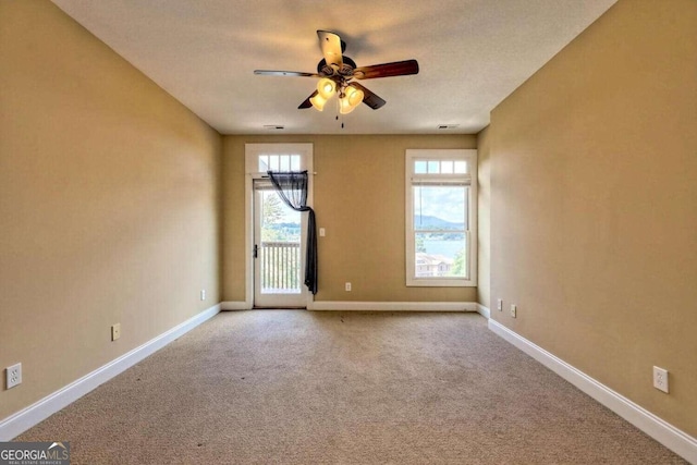 empty room with ceiling fan and carpet floors