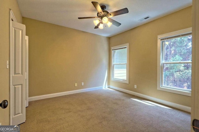 carpeted spare room featuring ceiling fan