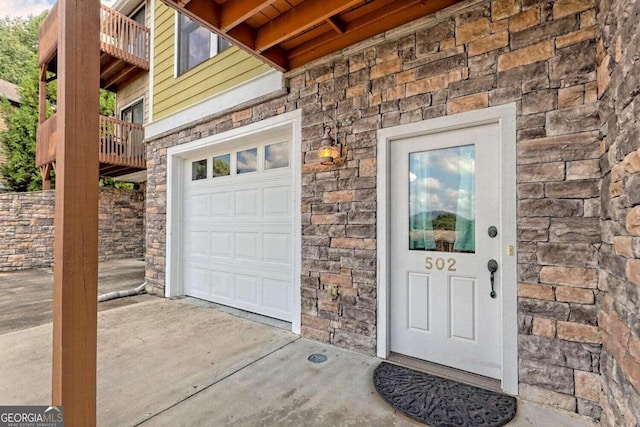 doorway to property with a balcony and a garage