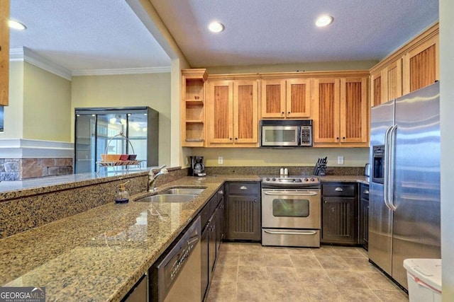 kitchen featuring appliances with stainless steel finishes, light stone countertops, a textured ceiling, and sink