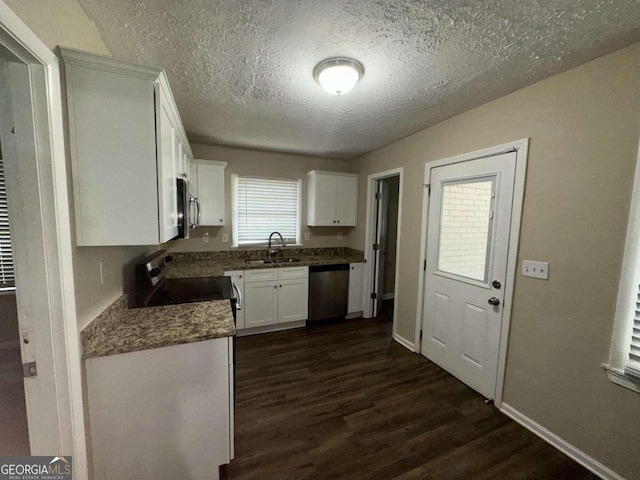 kitchen featuring a textured ceiling, dark hardwood / wood-style floors, stainless steel appliances, sink, and white cabinetry