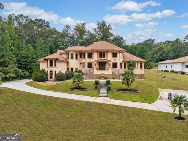 mediterranean / spanish home with a front lawn