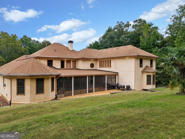 back of property featuring a sunroom and a lawn