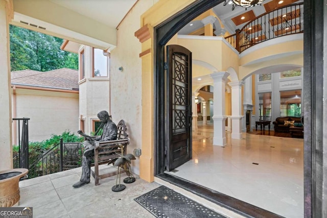 view of exterior entry with a balcony and french doors