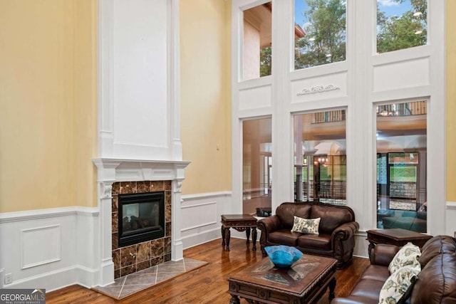 living room featuring a tile fireplace, hardwood / wood-style floors, and a wealth of natural light