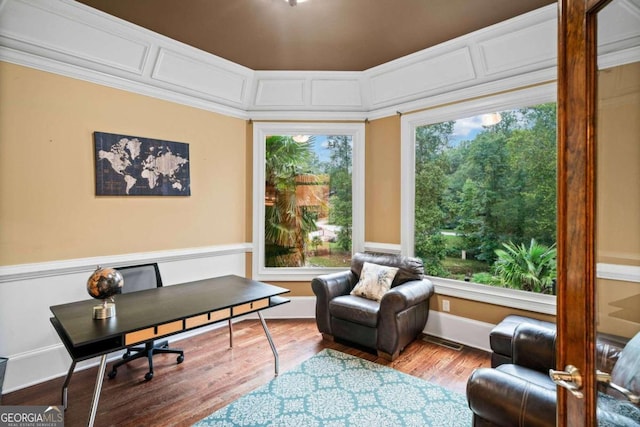 living area with ornamental molding and hardwood / wood-style floors